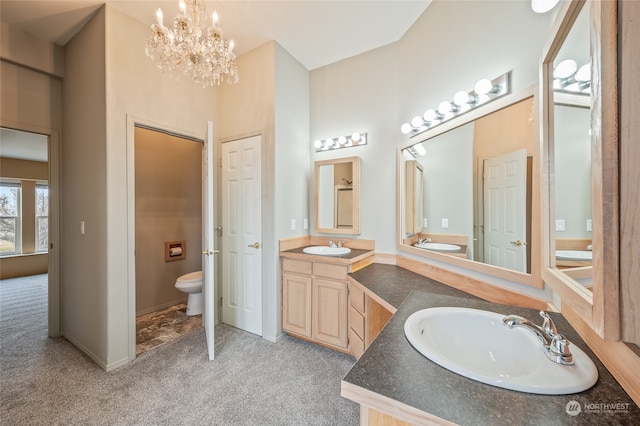 bathroom featuring vanity, toilet, and a chandelier