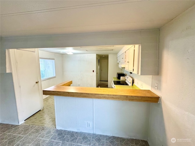 kitchen featuring white cabinets, kitchen peninsula, and white electric range