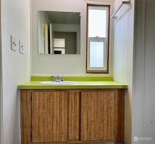 4815 NE Airway Dr Unit 12, Moses Lake, WA 98837 - bathroom with a textured wall, vanity, and healthy amount of natural light