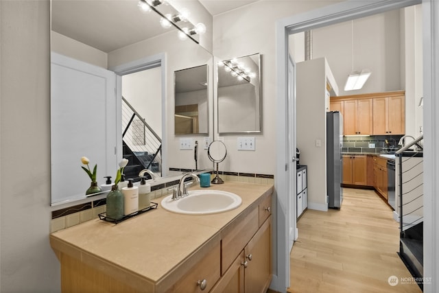 bathroom with decorative backsplash, hardwood / wood-style floors, and sink