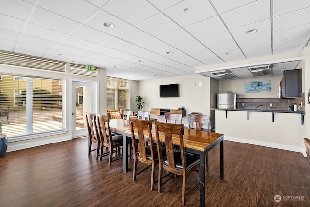 dining space with a paneled ceiling and dark wood-type flooring