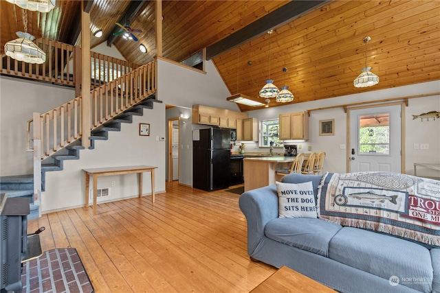 27525 W Lake Riley Rd, Arlington, WA 98223 - living area with high vaulted ceiling, stairway, wood ceiling with exposed beams, light wood-style flooring, and a wood stove