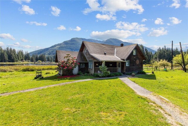 27525 W Lake Riley Rd, Arlington, WA 98223 - log-style house with covered porch, a front lawn, a chimney, and a water and mountain view