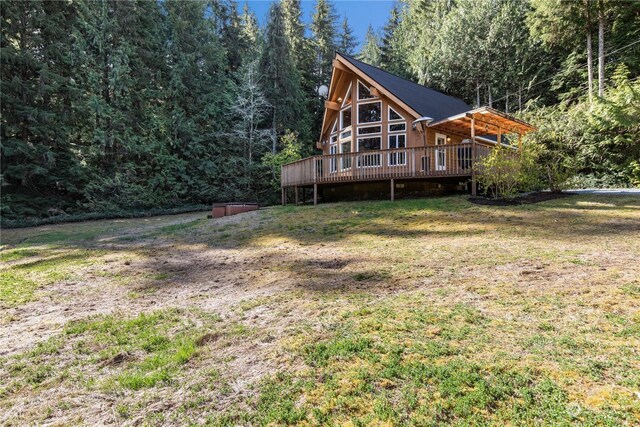 27525 W Lake Riley Rd, Arlington, WA 98223 - rear view of house with a deck, a wooded view, a lawn, and metal roof