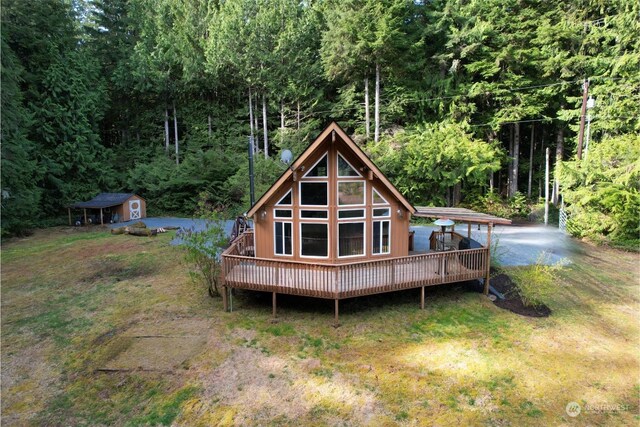 27525 W Lake Riley Rd, Arlington, WA 98223 - back of house with a wooden deck, a forest view, and a yard