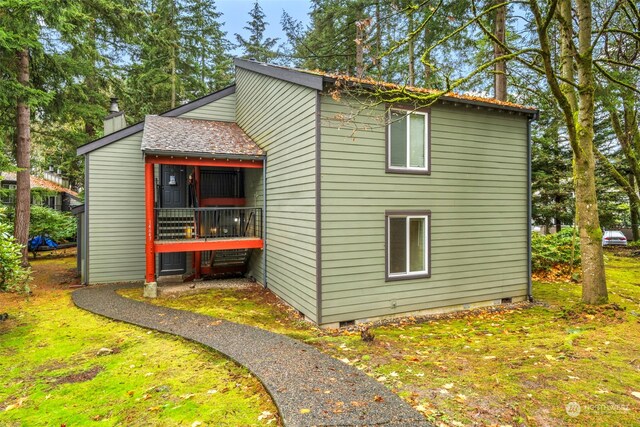 view of home's exterior featuring crawl space, a yard, and a chimney