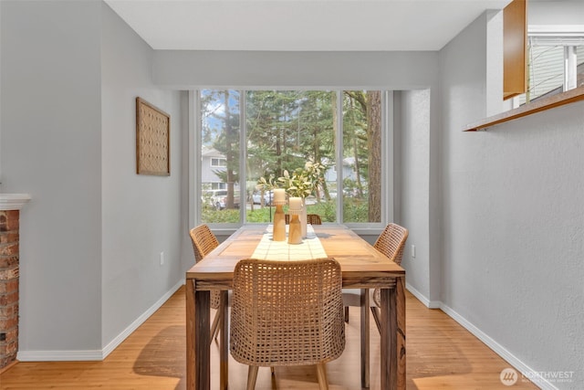 dining area featuring baseboards and light wood finished floors