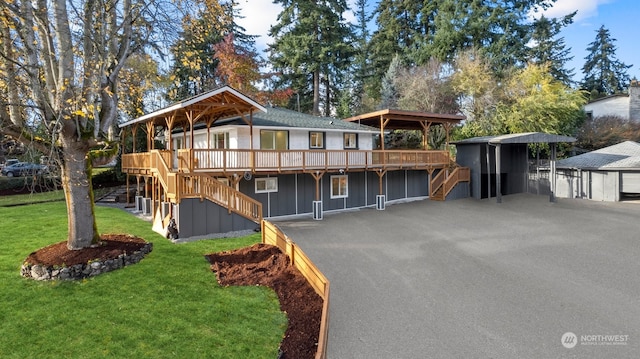 view of front of property with a wooden deck, a front lawn, and a carport