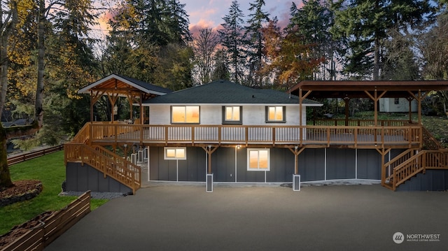 back house at dusk with a deck