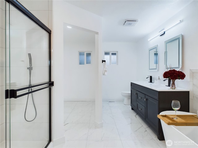 bathroom featuring marble finish floor, tiled shower, vanity, and toilet