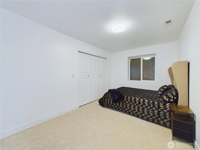 carpeted bedroom featuring visible vents, baseboards, and a closet