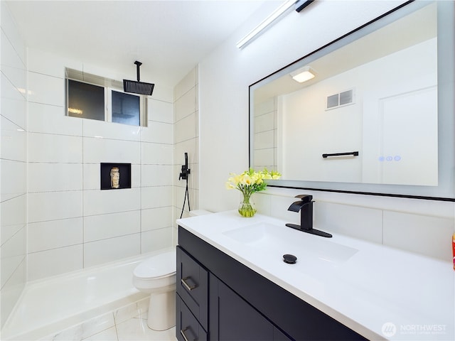 full bathroom with toilet, visible vents, a tile shower, and vanity