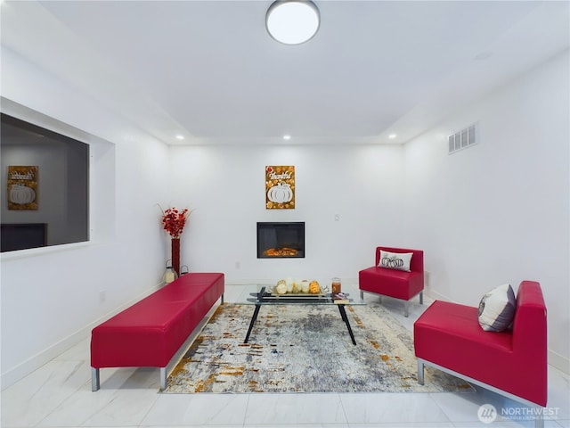 living room featuring marble finish floor, recessed lighting, visible vents, a glass covered fireplace, and baseboards