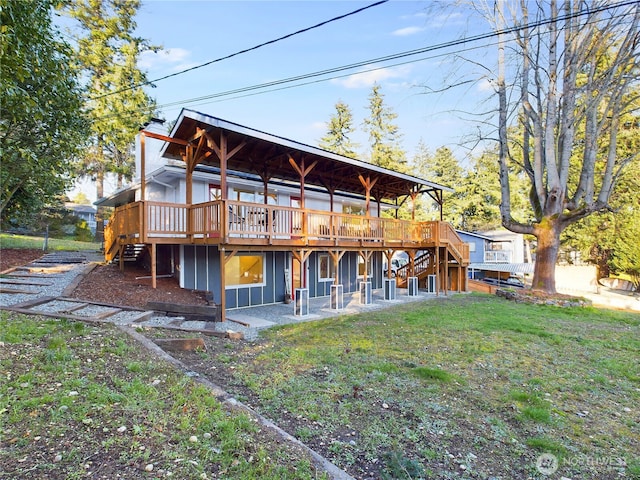 rear view of house featuring stairway, a deck, board and batten siding, and a yard