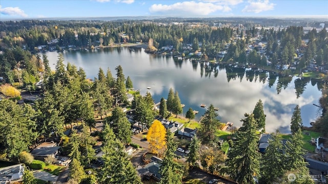 birds eye view of property featuring a water view and a wooded view