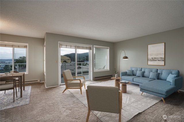 carpeted living room featuring plenty of natural light, baseboard heating, and a textured ceiling