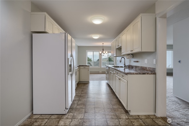 kitchen with white cabinetry, white fridge with ice dispenser, sink, and hanging light fixtures