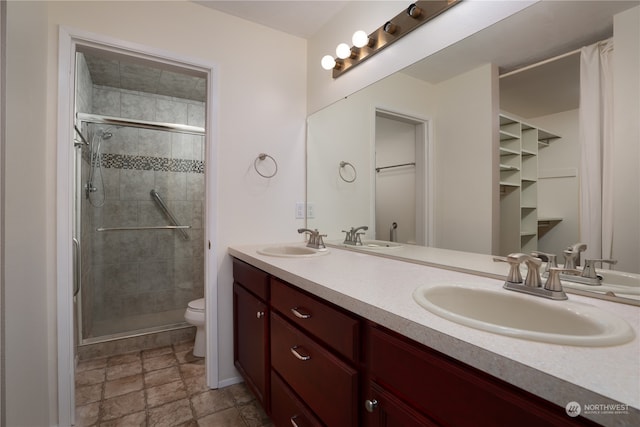 bathroom featuring vanity, an enclosed shower, and toilet