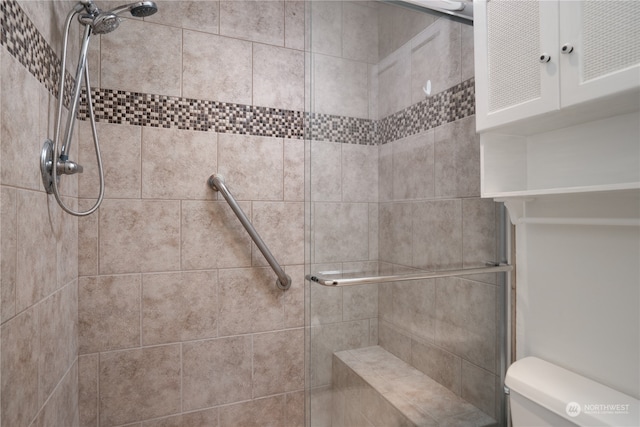 bathroom featuring toilet and a shower with door