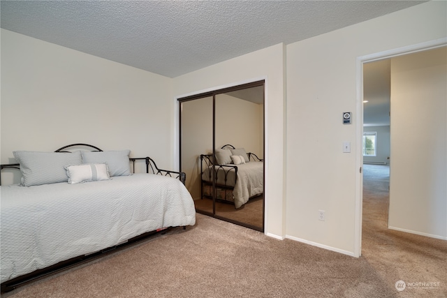 carpeted bedroom featuring a textured ceiling and a closet