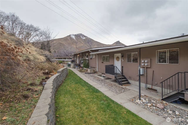 exterior space featuring a mountain view and a front lawn