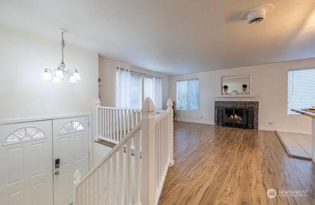 corridor featuring hardwood / wood-style flooring, an inviting chandelier, and a healthy amount of sunlight