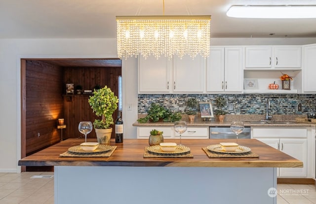 kitchen featuring wooden counters, backsplash, sink, dishwasher, and white cabinetry