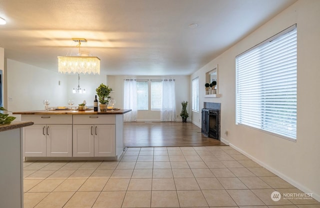 kitchen featuring white cabinets, pendant lighting, and a healthy amount of sunlight