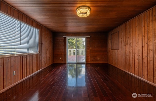 unfurnished room with wood ceiling, wooden walls, and dark wood-type flooring