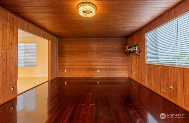 empty room featuring plenty of natural light, wood walls, wood-type flooring, and wooden ceiling