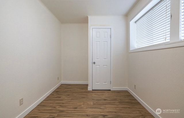 empty room featuring crown molding and dark wood-type flooring