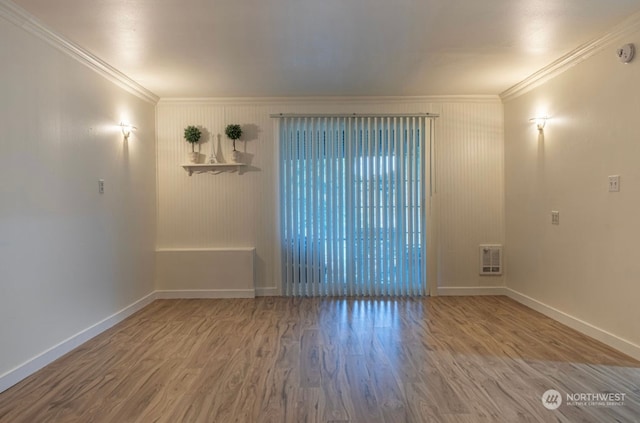 spare room featuring ornamental molding and hardwood / wood-style flooring