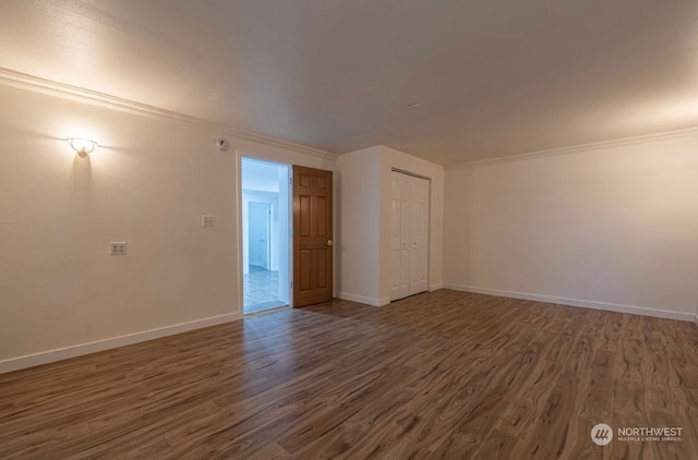 empty room with ornamental molding and dark wood-type flooring