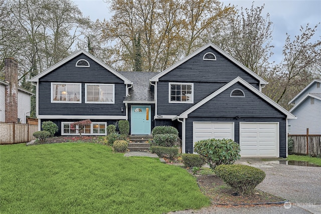 view of front of home with a front yard and a garage