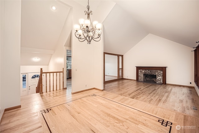 unfurnished living room featuring a fireplace, hardwood / wood-style floors, a chandelier, and vaulted ceiling