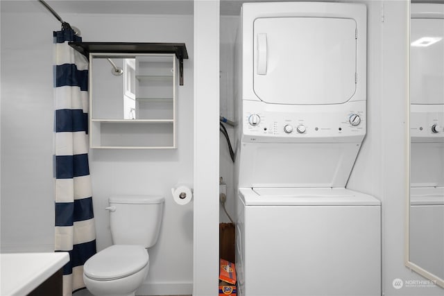 bathroom with curtained shower, toilet, and stacked washing maching and dryer