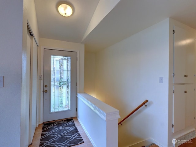 entryway featuring light wood-type flooring and vaulted ceiling