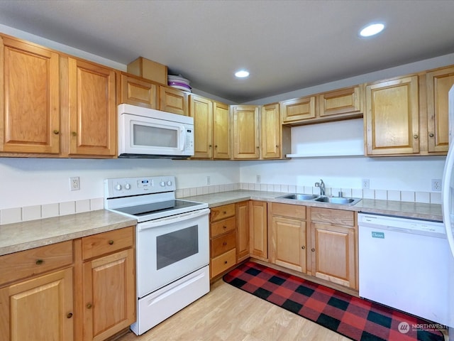 kitchen featuring sink, light hardwood / wood-style floors, and white appliances