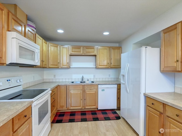 kitchen featuring light brown cabinets, sink, white appliances, and light wood-type flooring