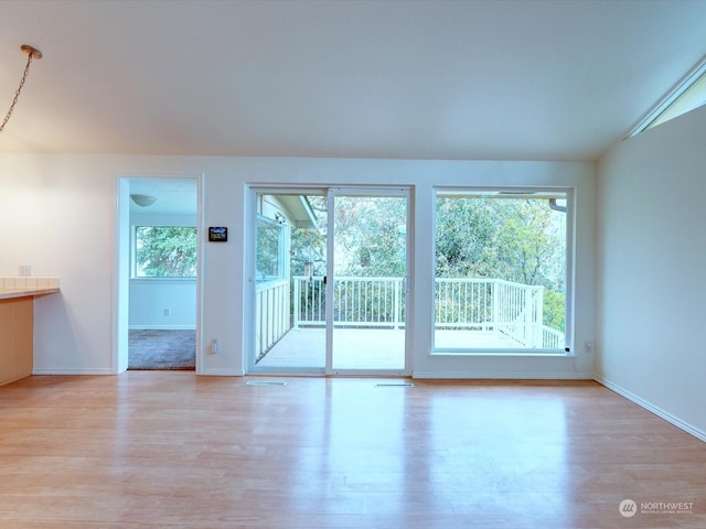 interior space with light wood-type flooring and lofted ceiling