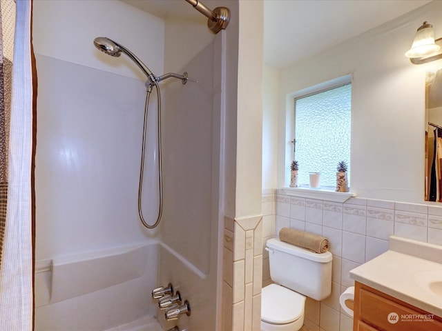 bathroom with walk in shower, vanity, toilet, and tile walls