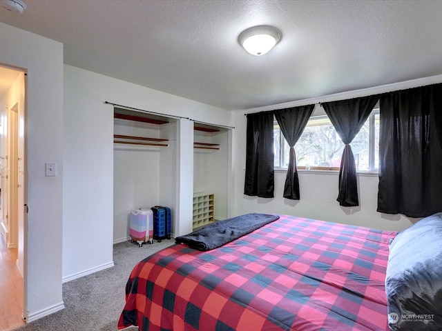 carpeted bedroom with a textured ceiling and a closet