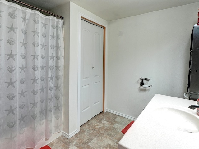 bathroom with curtained shower and vanity