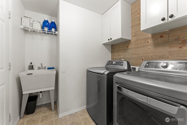 clothes washing area featuring washer and dryer and cabinets