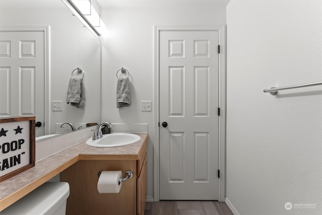 bathroom with vanity, hardwood / wood-style flooring, and toilet