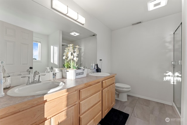 bathroom with tile patterned floors, vanity, toilet, and an enclosed shower