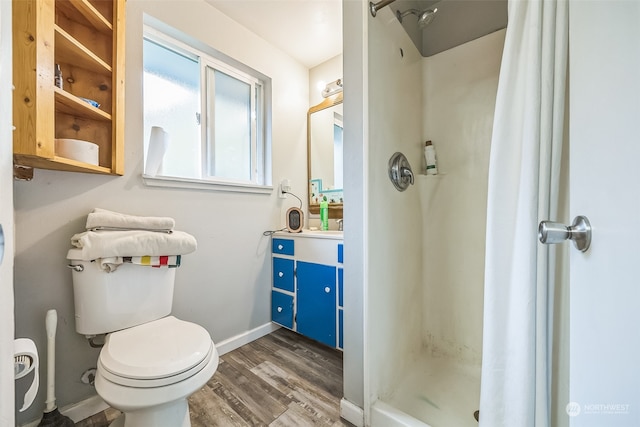 bathroom with hardwood / wood-style flooring, toilet, and walk in shower