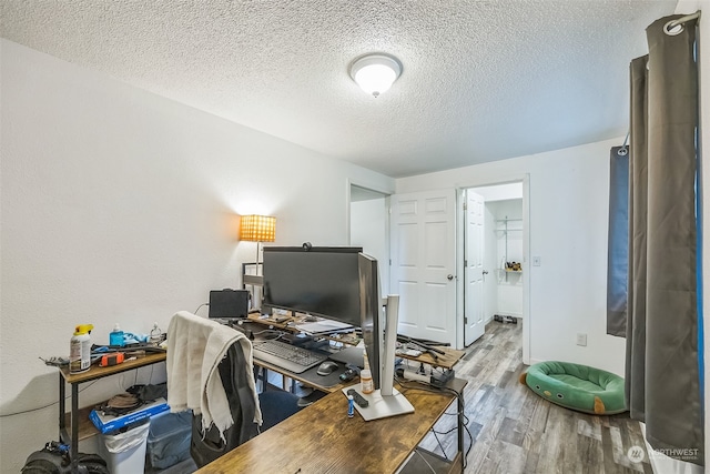 home office featuring wood-type flooring and a textured ceiling