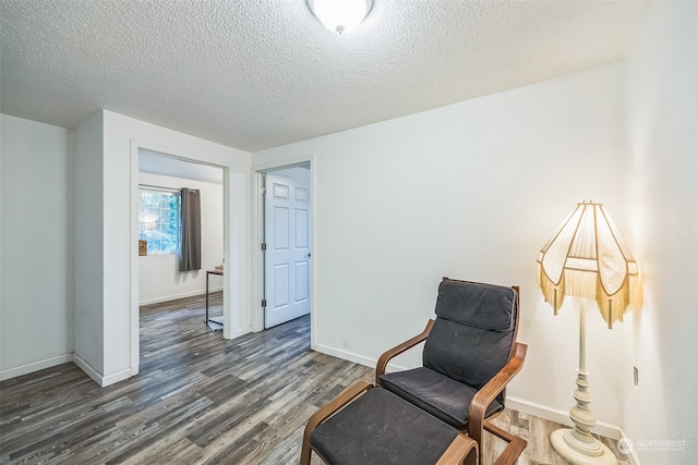 sitting room with dark hardwood / wood-style flooring and a textured ceiling