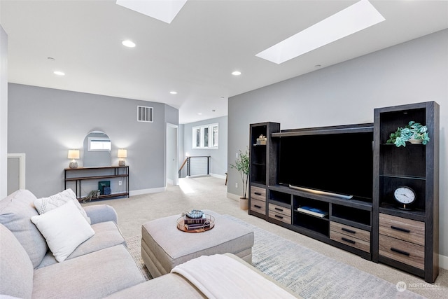 carpeted living room featuring a skylight